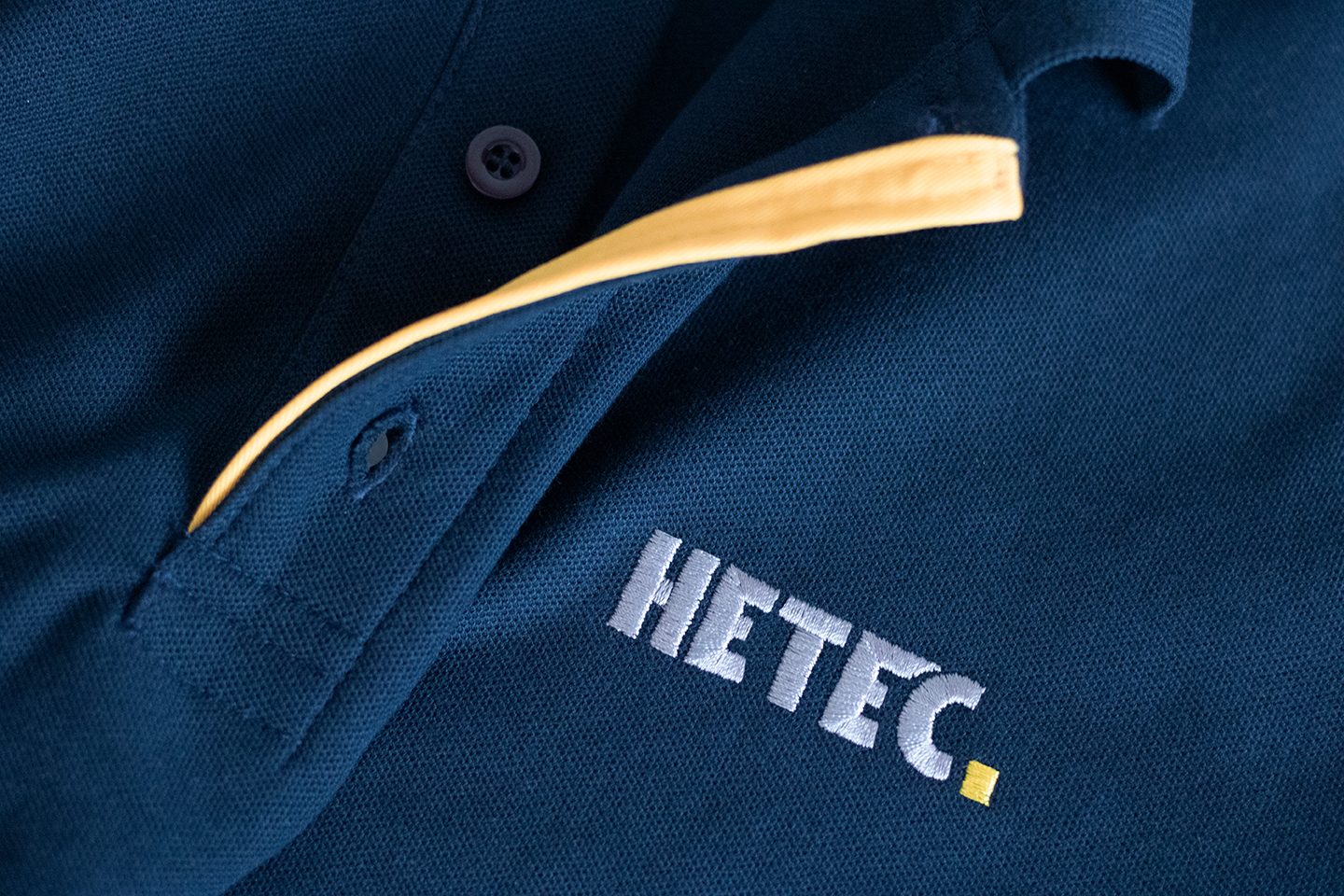HETEC-Firmenlogo bestickt auf marineblauem Polo &ndash; hdw.media Stickerei